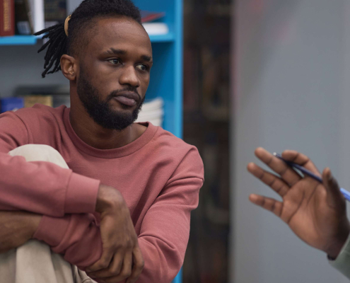 Two men in a workplace environment talking.